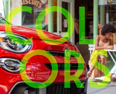 The word "Colors" in green over the front end of a red 2023 Fiat 500X Sport.