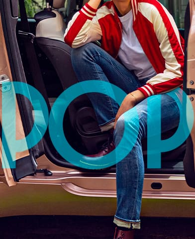 The word "Pop" in blue over a person sitting partially inside and partially outside of a rose gold 2024 Fiat European model.